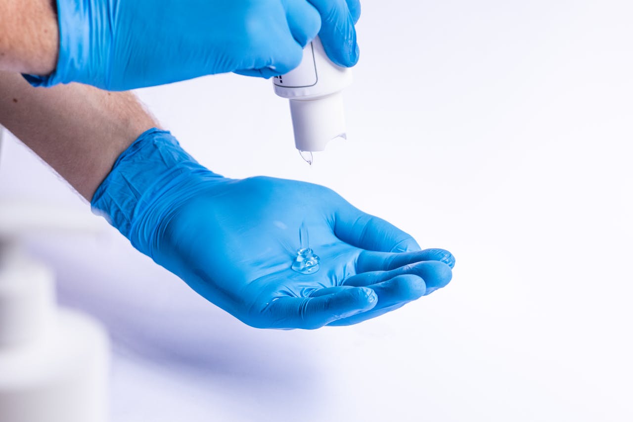Mastering the First Impression: Your intriguing post title goes here Crop anonymous medic applying antibacterial gel on blue latex gloves on white background in light room in hospital